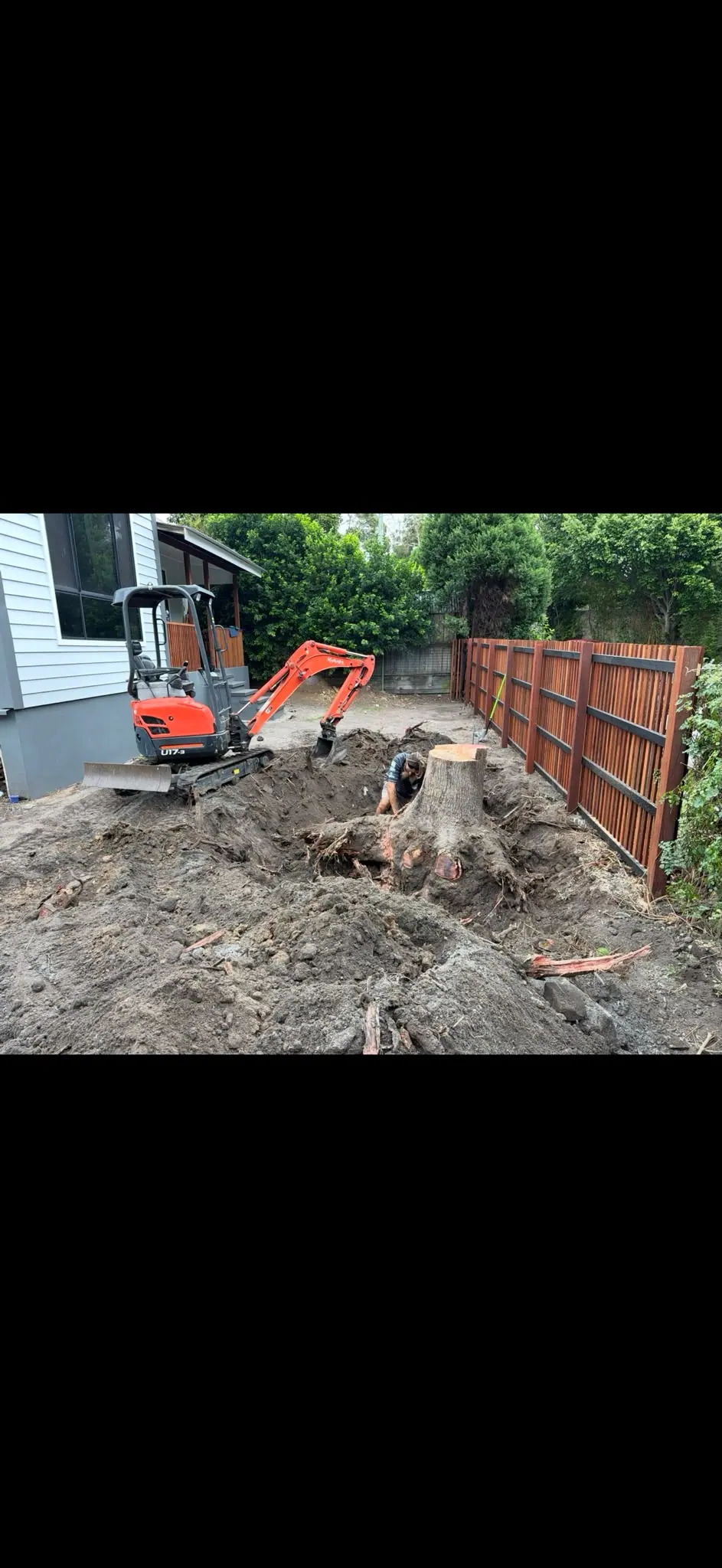 Stump excavation beside a home