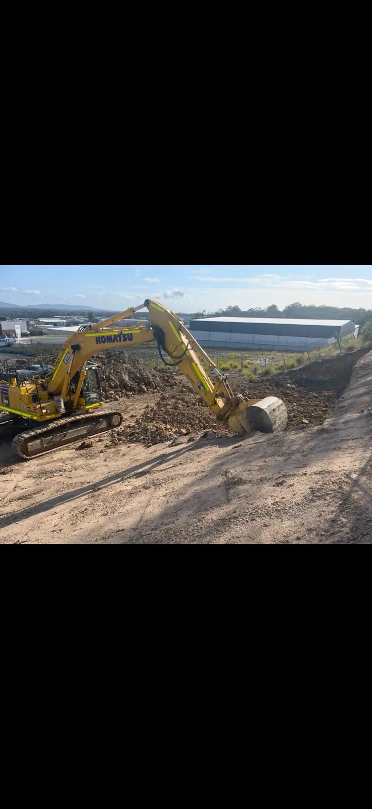Excavator shaping a slope