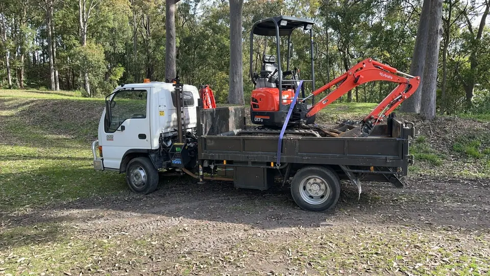 Truck carrying a mini excavator
