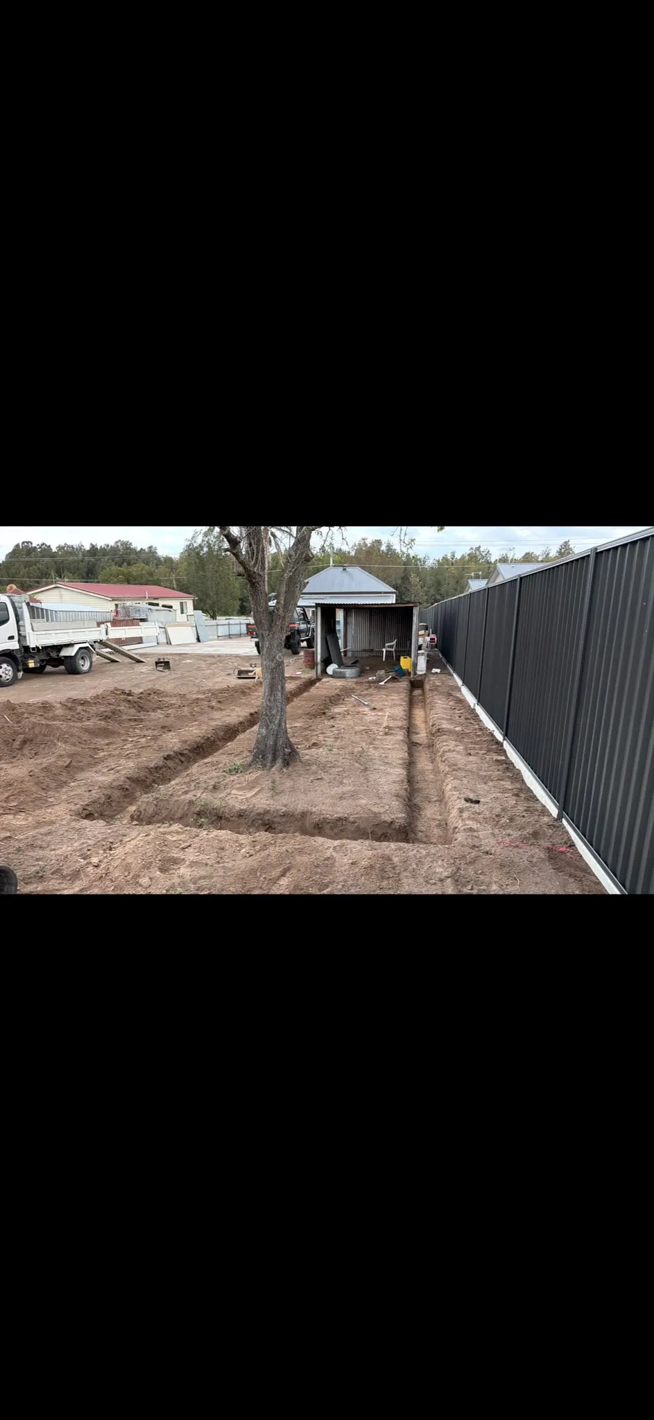 Residential footing trenches beside a fence
