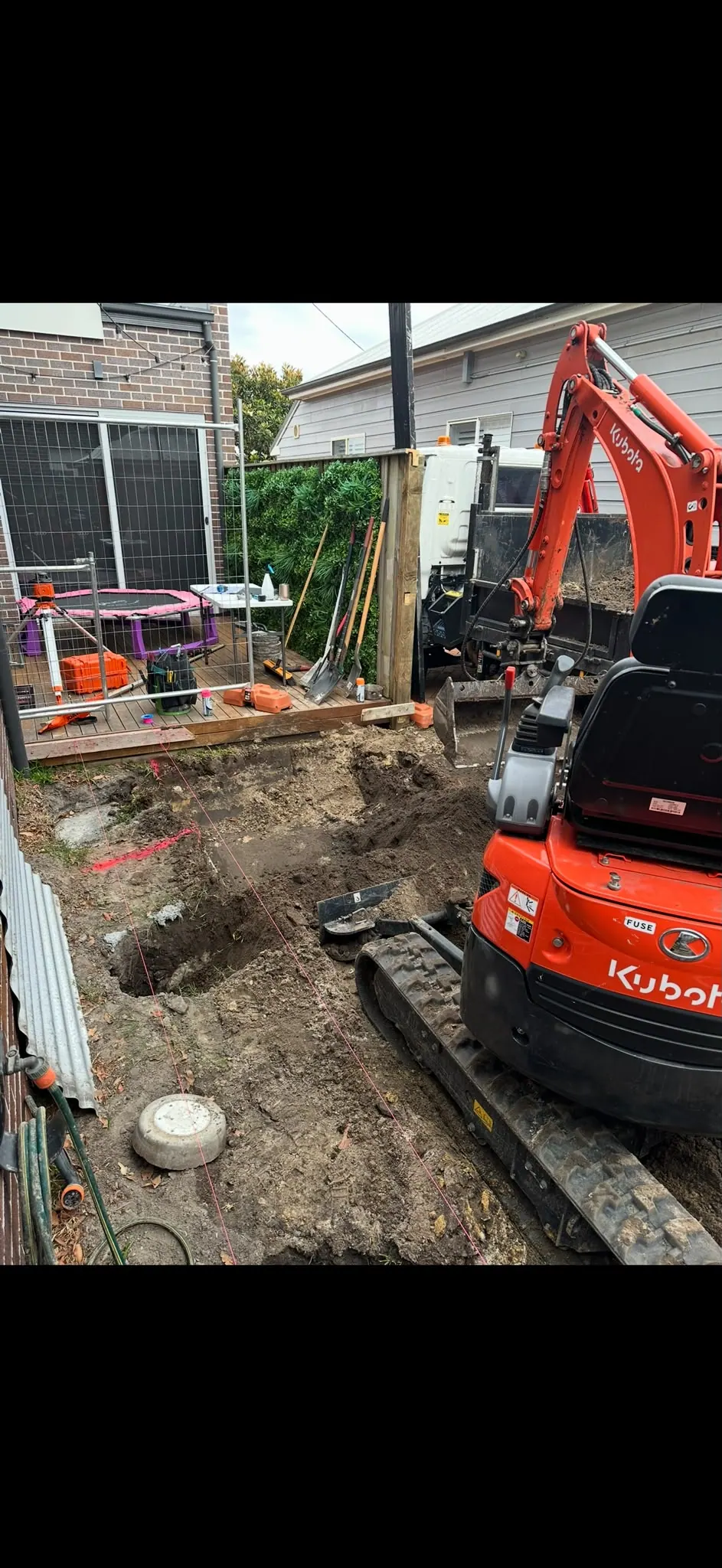 Mini excavator working beside a deck